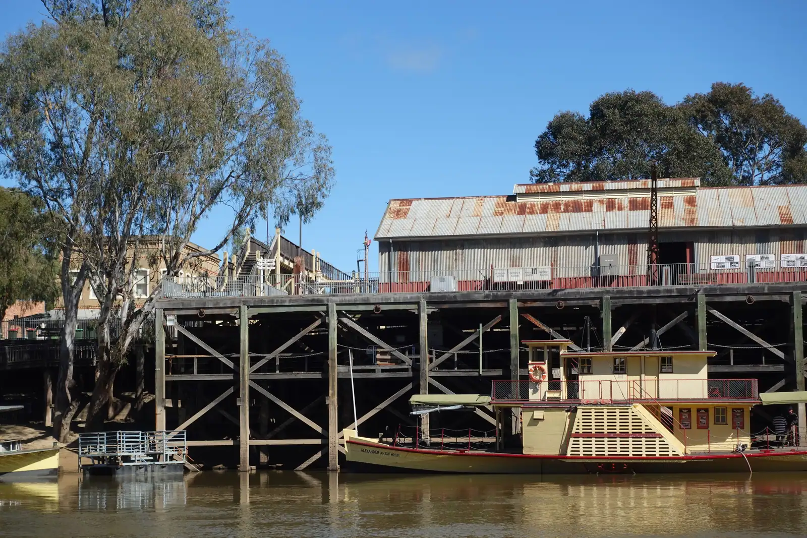A paddle steamer moored beneath the timber wharf at Echuca.